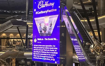 Retail storefront with bright digital window display showcasing seasonal campaign and promotions